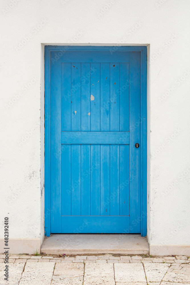 traditional white Greek house facade with blue door