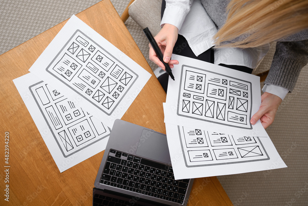 Naklejka premium Woman designer create website design wireframe. Sketch, prototype, framework, layout future design project. UI and UX - user interface, user experience designer. Creative concept for web design studio