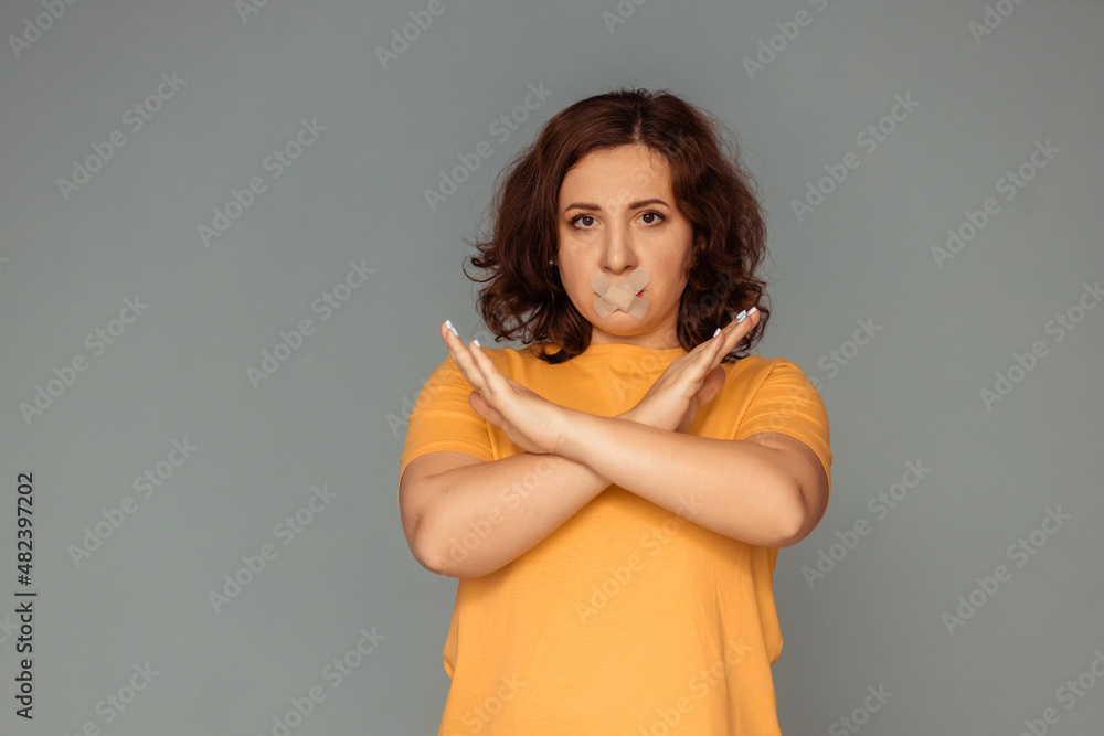 acute social problems. girl with a band-aid over her mouth and a stop sign acute social problems. girl with a band-aid over her mouth and a stop sign