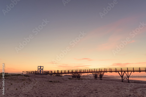 wooden bridge over the sea at sunset