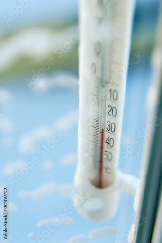 Classic mercury thermometer for measuring ambient temperature, hanging outside the window, with readings minus 30 degrees Celsius.
