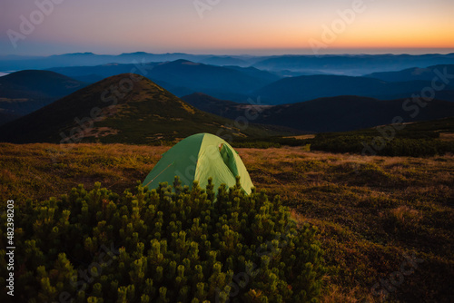 Green camping tent on top of mountain with amazing view © WellStock
