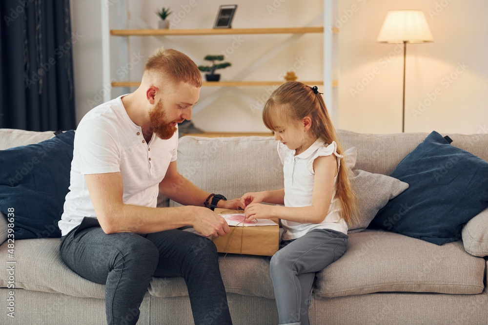 With gift box. Father with his little daughter is at home together With gift box. Father with his little daughter is at home together