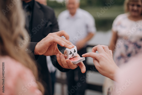 magician shows trick with cards