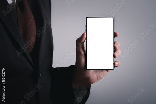 Fototapeta Naklejka Na Ścianę i Meble -  Close up hands of business man holding smartphone with white screen. social communication technology concept. Work on mobile phone application.
