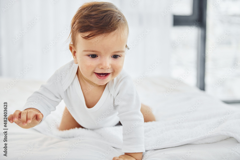 Having fun. Cute little baby is indoors in the domestic room Having fun. Cute little baby is indoors in the domestic room