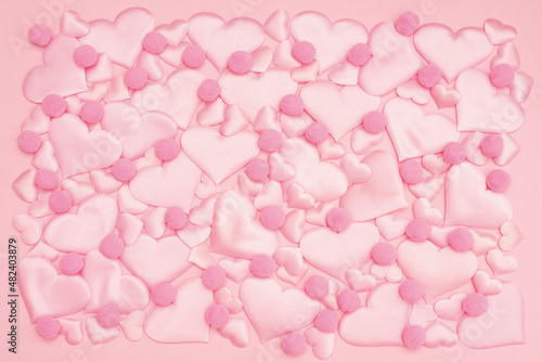 beautiful delicate background of voluminous pink satin hearts of different sizes and a fluffy balls arranged in the style of puzzles . Valentine's day background