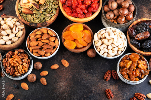 Nuts and dried fruits assortment. Healthy snacks. Dried apricots, figs, raisins, pecans, walnuts, hazelnuts, almonds and other. Brown table background