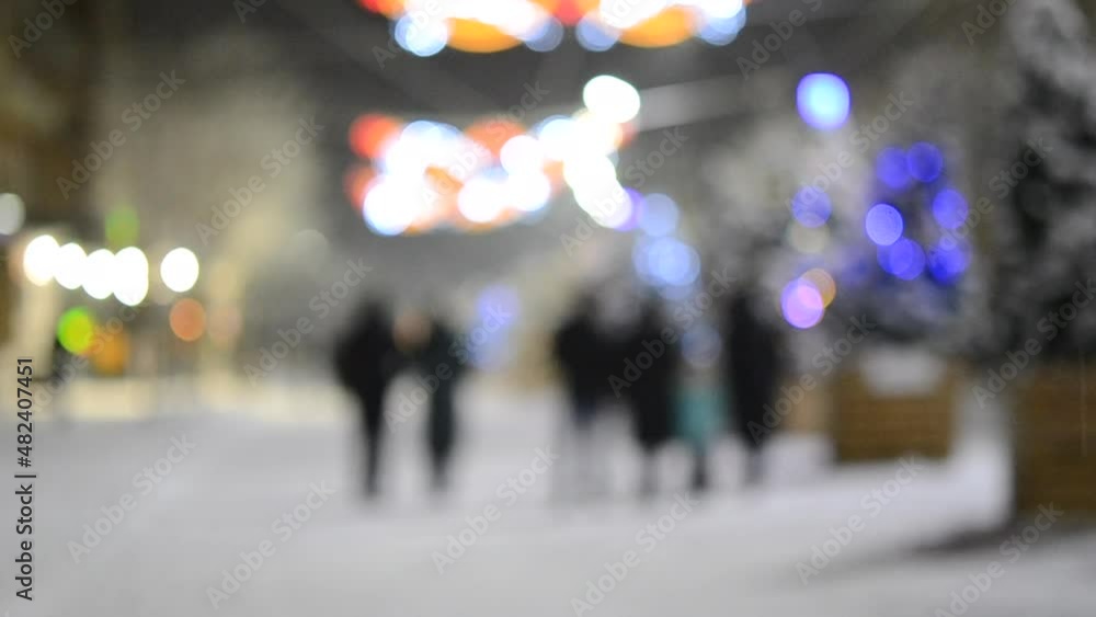 Blurred background. City street during snowfall at winter night. Beautiful illumination and decoration on street. New Year Christmas holidays celebration. Lanterns garlands on trees. Blurred background. City street during snowfall at winter night. Beautiful illumination and decoration on street. New Year Christmas holidays celebration. Lanterns garlands on trees.