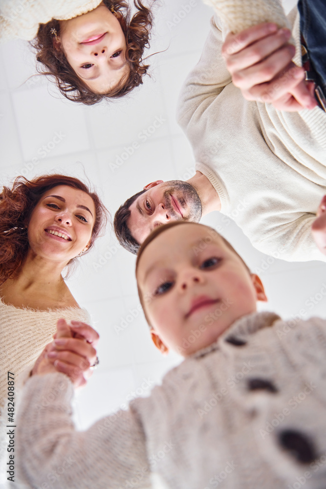 View from below. Happy family looking down and having fun View from below. Happy family looking down and having fun