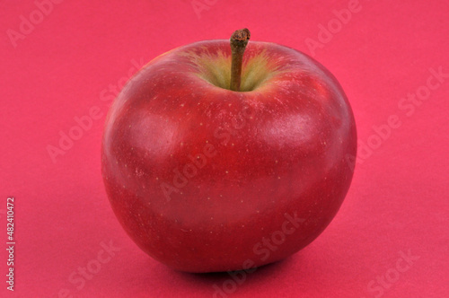 Pomme en gros plan sur fond rouge