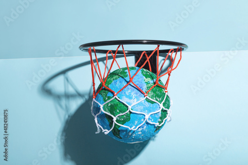 Small Earth ball in basketball hoop photo