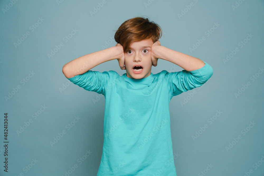 Ginger white boy expressive surprise while covering his ears Ginger white boy expressive surprise while covering his ears