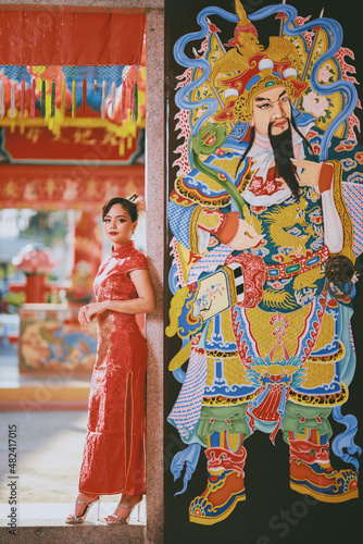 Beautiful Asian Chinese Woman Wearing Cheongsam Traditional Red Dress Fashion Posting Chinese Lunar New Year. © Narin Sapaisarn
