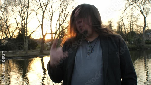 [4k] long haired hard rock fan singing in the park headbanging