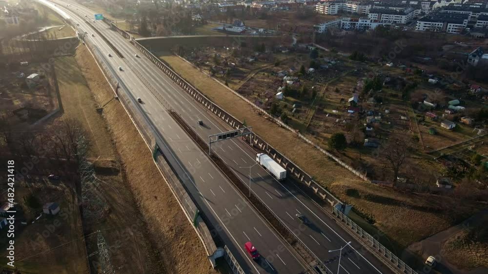 Car traffic moving on highway at sunset, aerial view. Road trip, delivery and logistic concept Car traffic moving on highway at sunset, aerial view. Road trip, delivery and logistic concept