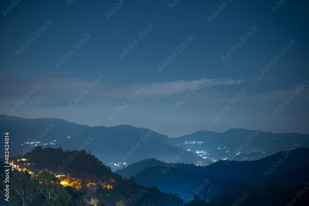 mountain view with night sky and light from downtown background
