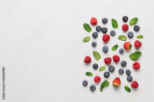 Variety of neatly arranged berries of raspberries, blueberries, strawberries on white background top view