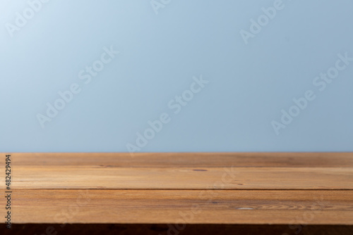 Empty wooden rustic brown table and blue pastel wall. Background with copy space side view