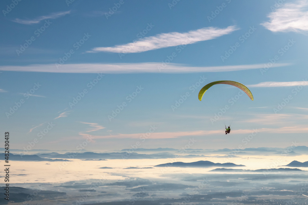 Paragliding with parachute at clear sunny sky in winter. Paragliding with parachute at clear sunny sky in winter.