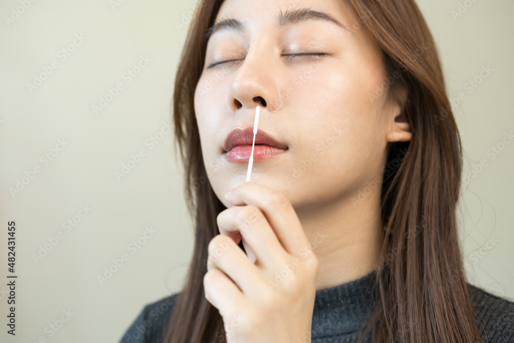 Pandemic of disease, asian young woman, girl hand holding atk, antigen kit self test. Introducing device nasal, nose swab test for possible infection of coronavirus, covid-19 at home. Health care.