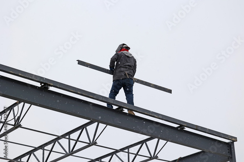 Construction workers walk on narrow beams