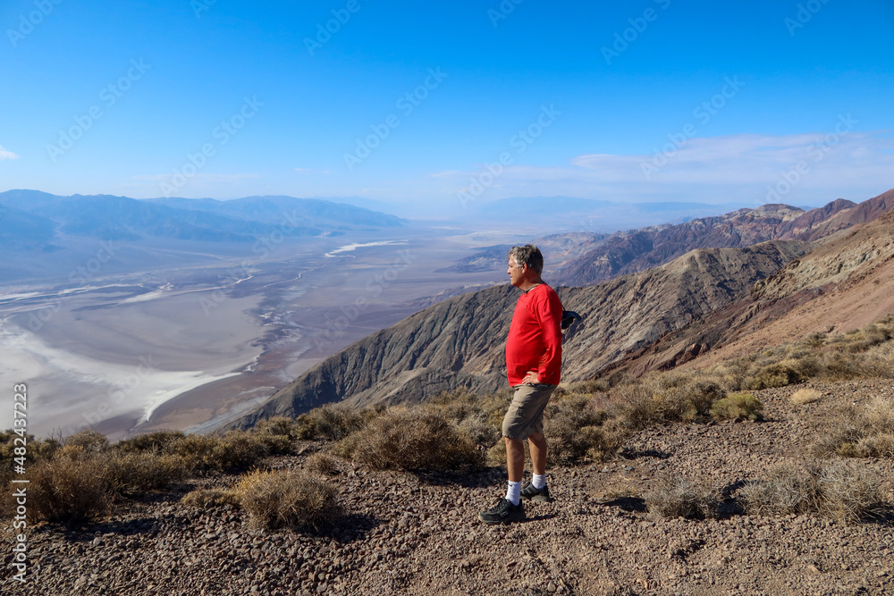 A Spunky and Adventurous Man Exploring the Dantes View in Death Valley, California Overlooking the Eroded Valley from the Cliff Exploring Earth Science Forces