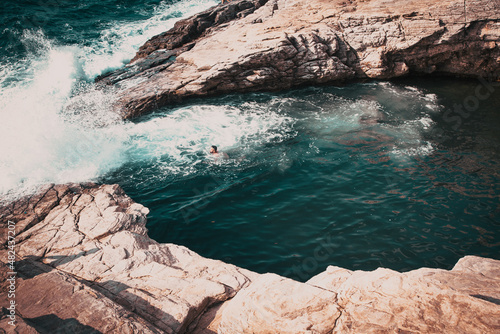 woman swimming in sea cove with turquoise water photo