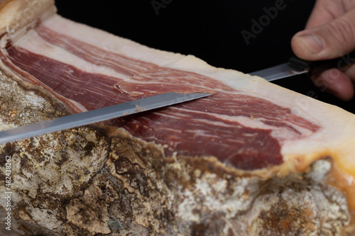 Iberian ham cutter, selective focus. A black background. The best serrano ham in the world comes from Jabugo, Huelva, Spain. Concept of the best gourmets.