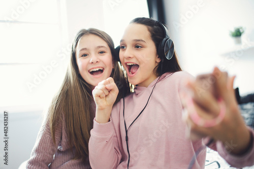 Two Teens spending time on bedroom at home to sing togerher photo