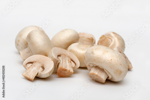 Champignons, close-up, on white background. Raw mushrooms ready for cooking.