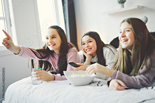 A pajama party with teens eat popcorn on the bed photo