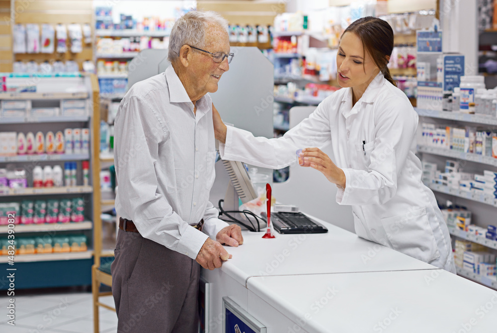 Assuring clients are informed. Shot of a young pharmacist helping an elderly customer at the prescription counter.