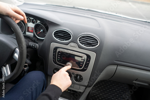 driver hand adjusting car multimedia  turn on radio