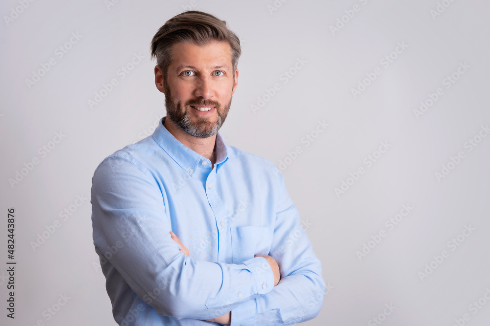 Smiling businessman standing with arms crossed at isolated white background Smiling businessman standing with arms crossed at isolated white background