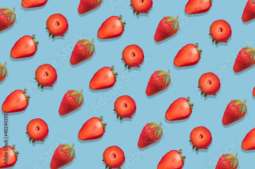Strawberry pattern on a  bright blue background, creative flat lay healthy food concept