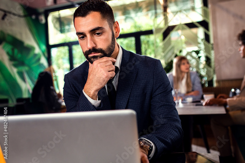 Young businessman working at cafe using laptop.