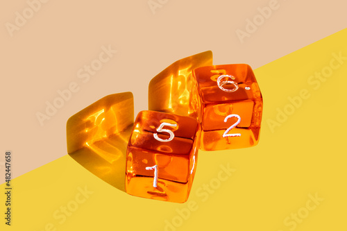 Orange plastic dice on a yellow background with the winning come out roll corresponding to a die with the number 5 and a die with the number 6 that add up to the number 11