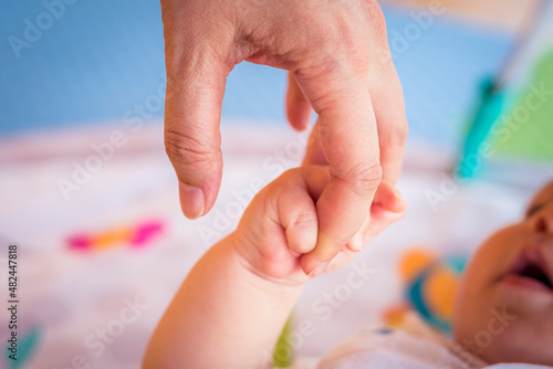 Mother and baby holding hands