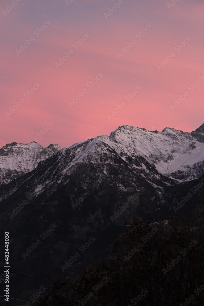 Purple and pink vivid sunset over snow capped alpine mountains (Aosta, Italy)	