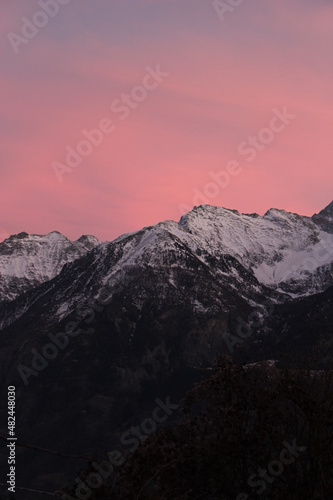 Purple and pink vivid sunset over snow capped alpine mountains  Aosta  Italy  