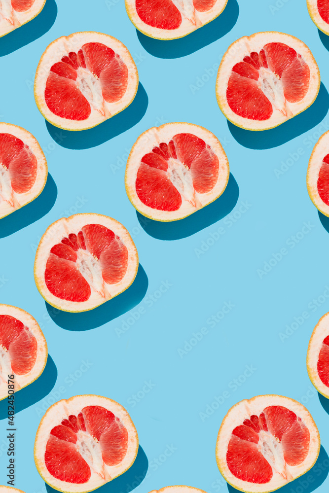 fruit pattern of fresh ripe slice grapefruits on blue background. top view fruit pattern of fresh ripe slice grapefruits on blue background. top view
