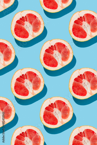 fruit pattern of fresh ripe slice grapefruits on blue background. top view