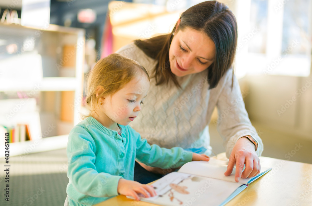Mother and child looking picture books together at the library Mother and child looking picture books together at the library