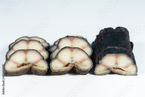 Close-up view stock photography of tasty sliced cooked smoked eel fish isolated on white background