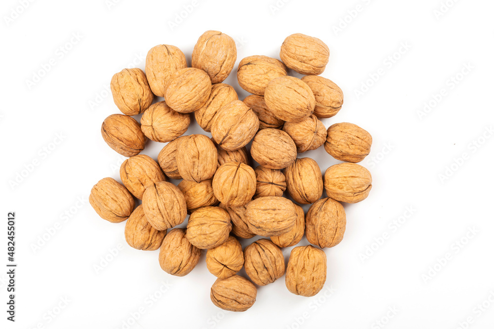 Top view of closed and broken walnuts scattered on white background with copy space Top view of closed and broken walnuts scattered on white background with copy space