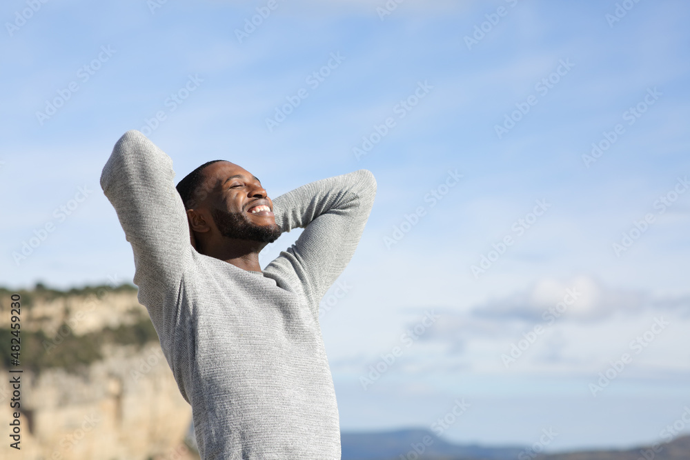 Relaxed man with black skin breathing in the mountain - obrazy, fototapety, plakaty 