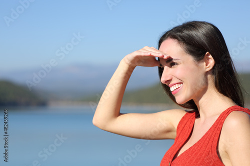 Woman covering eyes a sunny day searching in nature