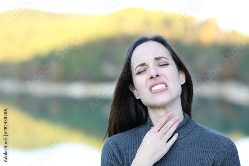 Fototapet Woman suffering sore throat complaining in nature