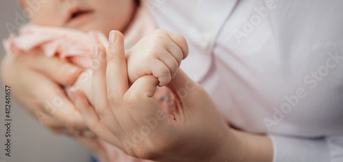 Banner Mother with newborn baby hold hands closeup. Concept help and support adoption